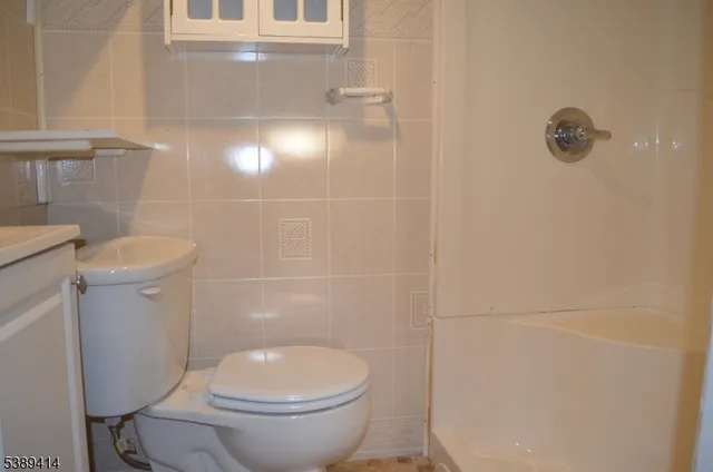 a white toilet sitting next to a bathroom sink