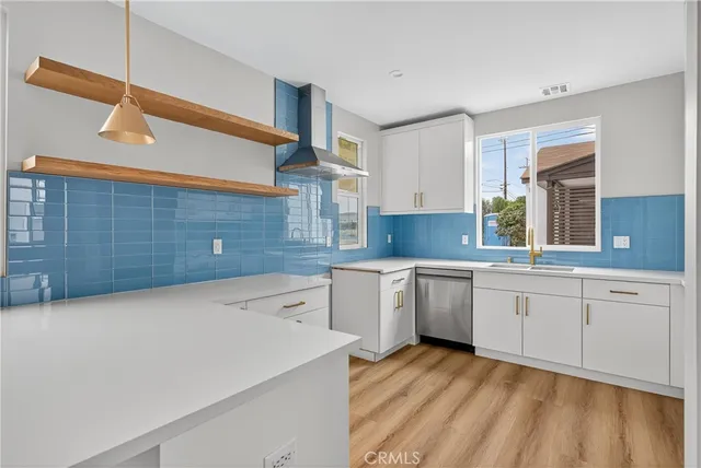 a large kitchen with a sink dishwasher stove and white cabinets