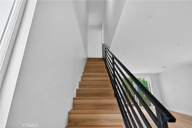 a view of a hallway with wooden floor and entryway