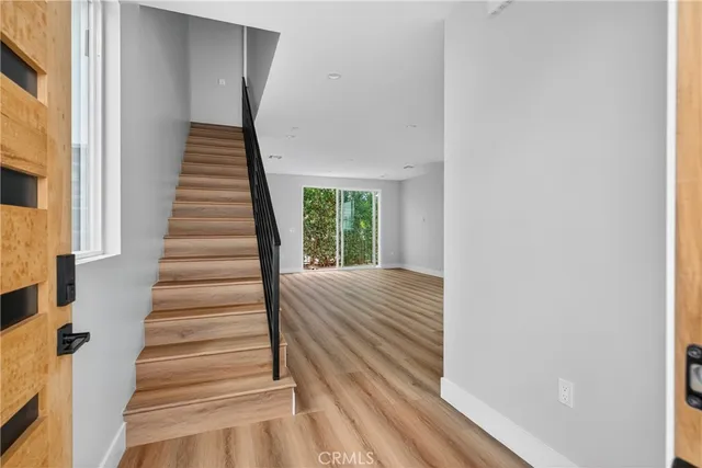 a view of a hallway with wooden floor and entryway