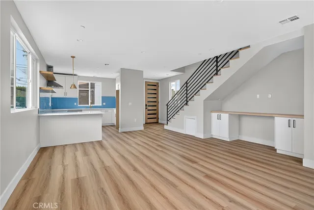 a view of a kitchen with wooden floor and electronic appliances