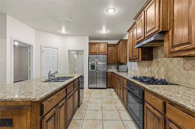 a kitchen with stainless steel appliances granite countertop a stove and a sink