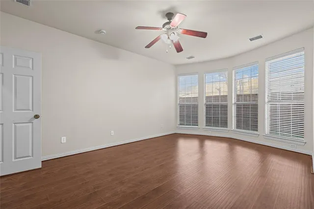 a view of wooden floor and a chandelier fan in a room