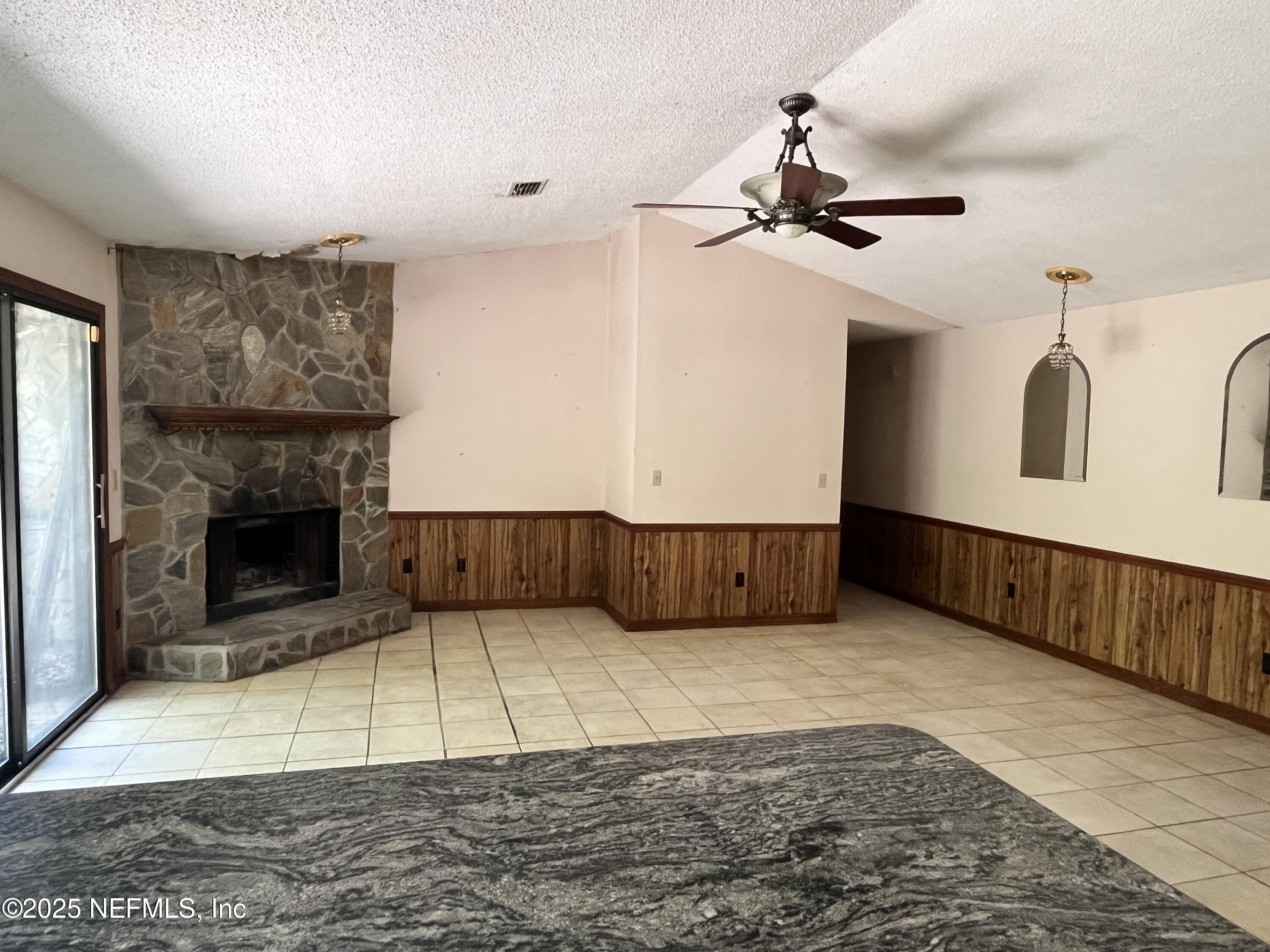 5511 Heckscher Drive Jacksonville, FL 32226 - Photo 9 of 19 a view of a livingroom with a fireplace a ceiling fan and windows