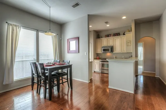 a kitchen with stainless steel appliances granite countertop wooden floor and white cabinets
