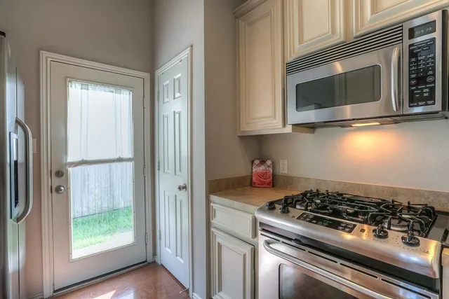 a kitchen with stainless steel appliances granite countertop a stove and a microwave