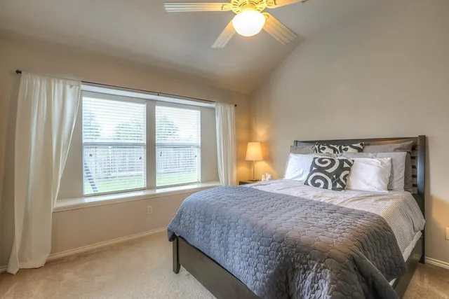 a bedroom with a large bed and a window