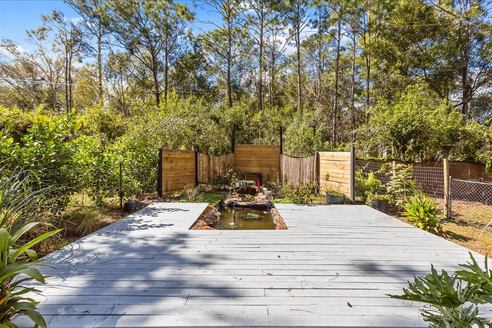 23801 Southwest Martin Highway Okeechobee, FL 34974 - Photo 39 of 85 a view of a patio with table and chairs with wooden fence and plants