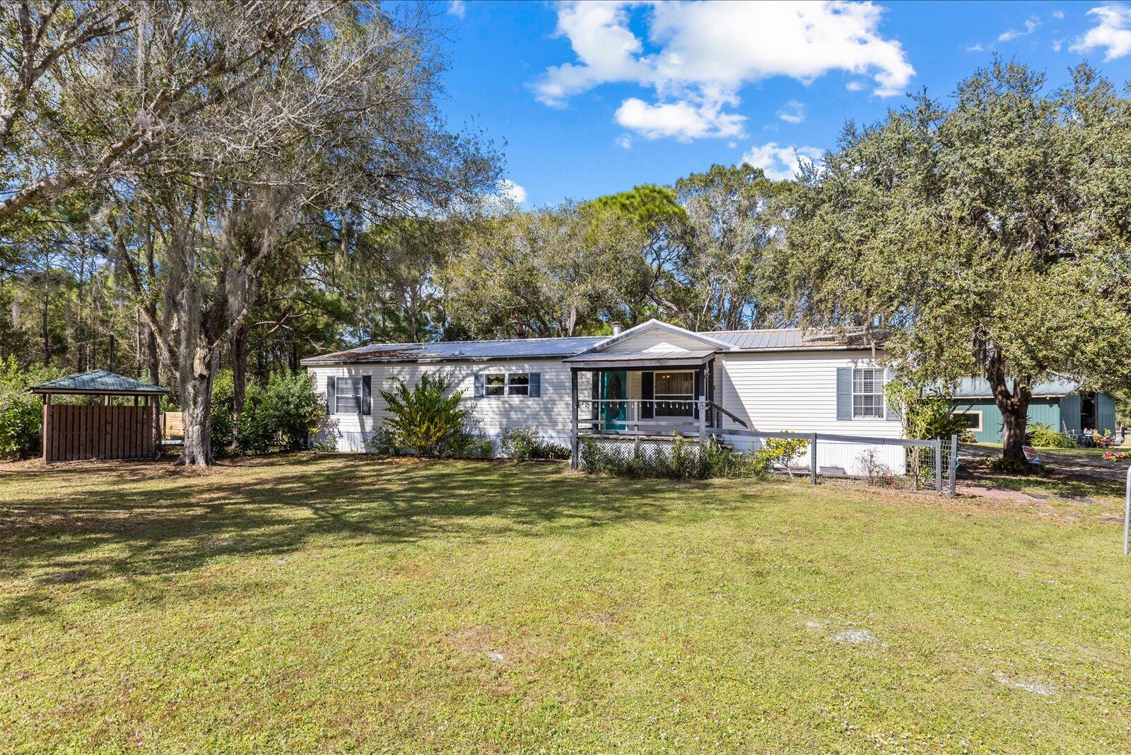 23801 Southwest Martin Highway Okeechobee, FL 34974 - Photo 4 of 85 a front view of a house with a garden