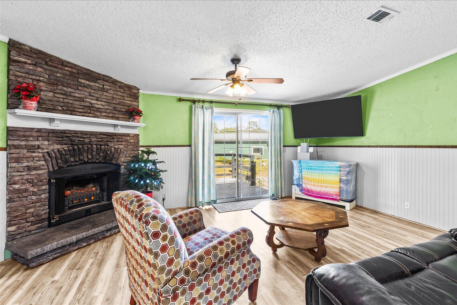 23801 Southwest Martin Highway Okeechobee, FL 34974 - Photo 47 of 85 a living room with furniture a fireplace and a flat screen tv