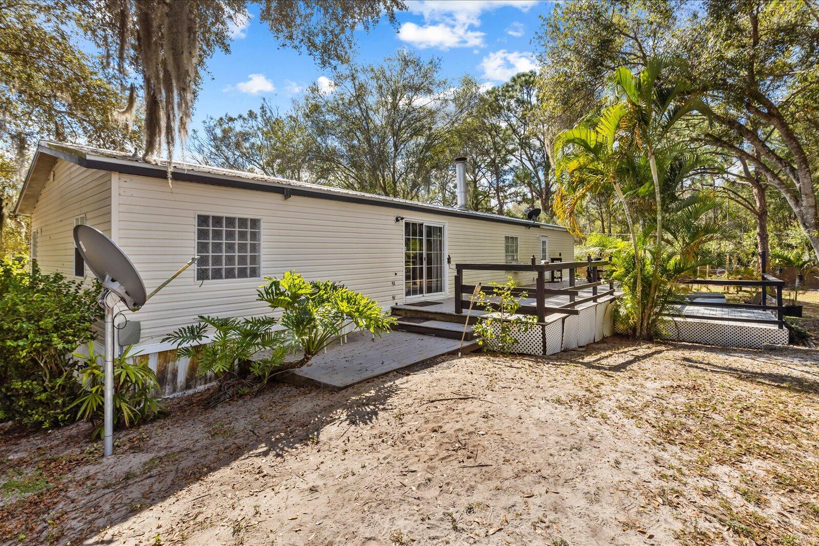 23801 Southwest Martin Highway Okeechobee, FL 34974 - Photo 69 of 85 a view of a backyard with chairs and a large tree
