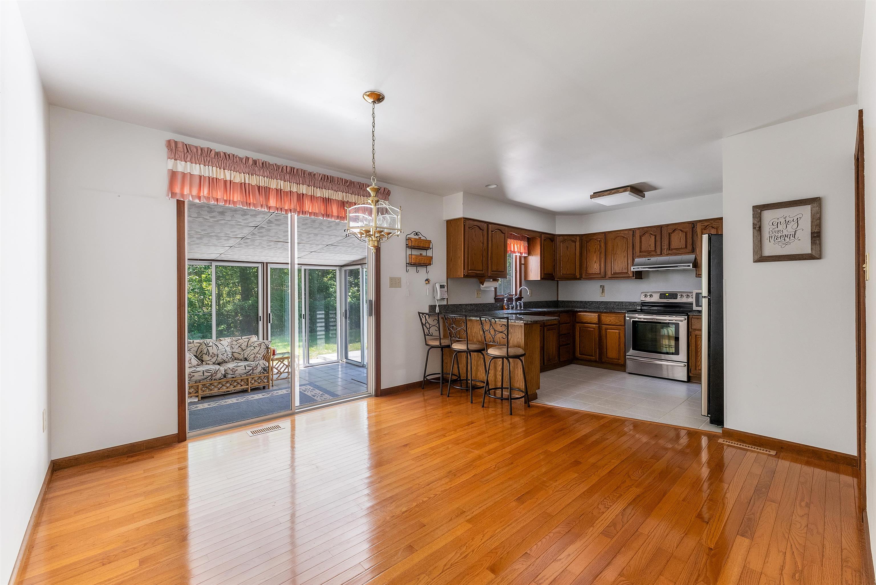 233 Fidler Road Dennisville, NJ 08270 - Photo 27 of 31 a kitchen with stainless steel appliances granite countertop a stove top oven a sink dishwasher a dining table and chairs with wooden floor