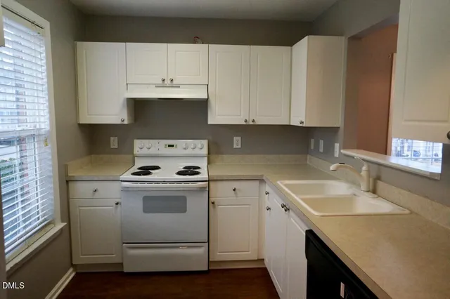a kitchen with granite countertop white cabinets and white appliances