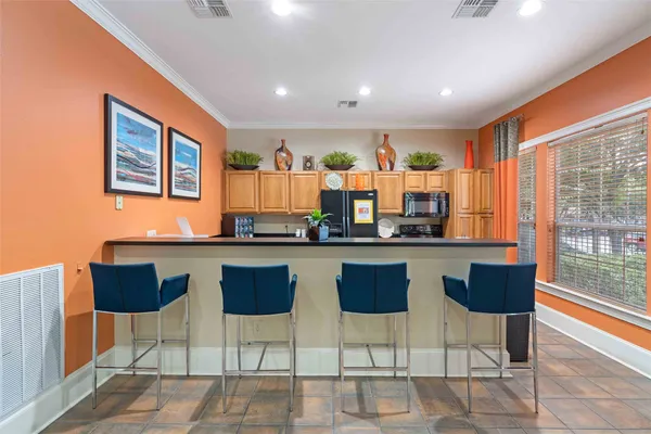 a kitchen with stainless steel appliances granite countertop a table and chairs in it