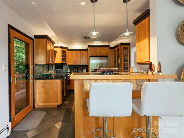 a kitchen with stainless steel appliances granite countertop a sink a stove and a refrigerator