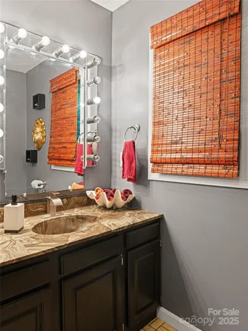 a bathroom with a granite countertop sink and a mirror