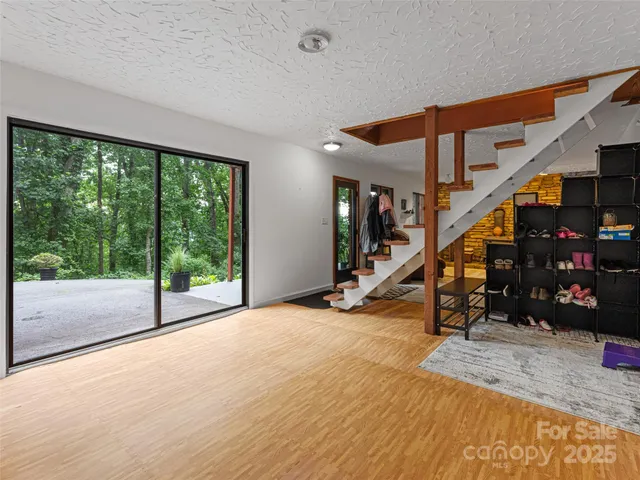 a view of a livingroom with wooden floor and stairs