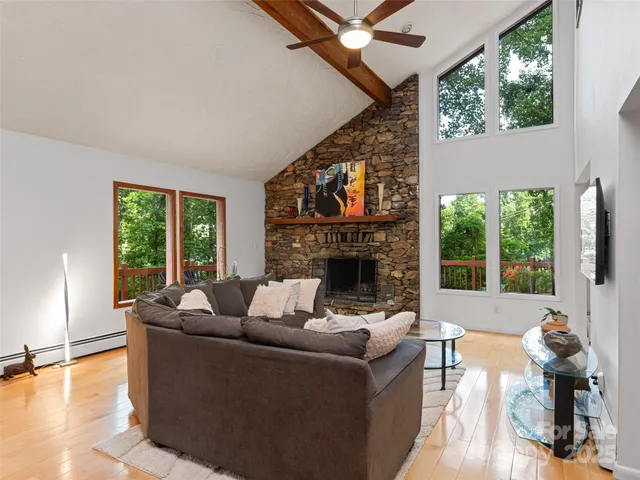 a living room with furniture a large window and a fireplace