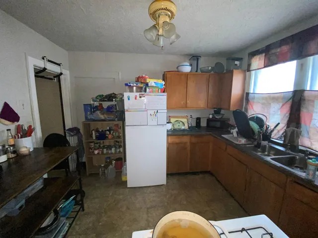 a kitchen with refrigerator and cabinets