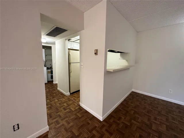 an empty room with wooden floor and cabinet