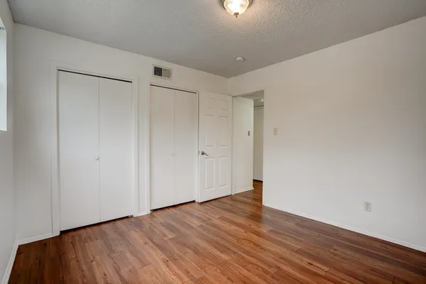 a view of an empty room with wooden floor