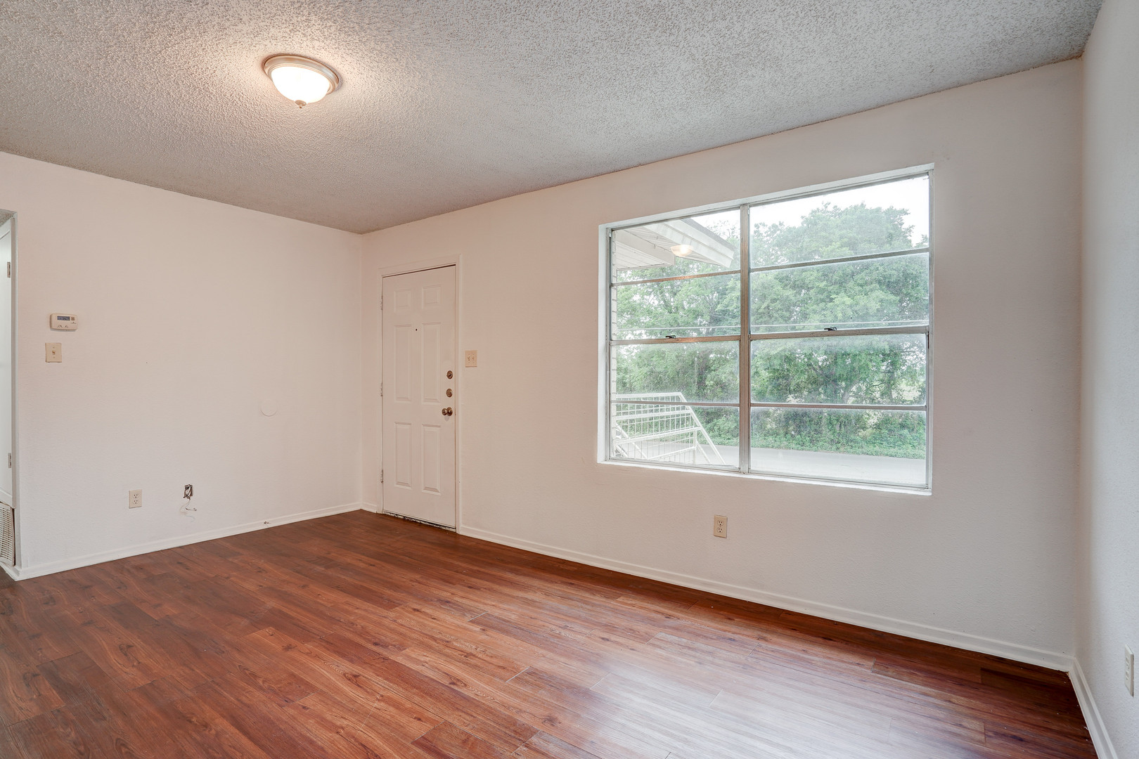 748 Old Martindale Road San Marcos, TX 78666 - Photo 4 of 18 an empty room with wooden floor and windows