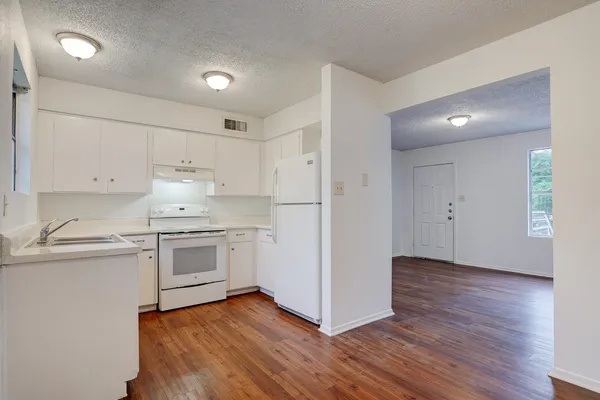 a kitchen with granite countertop white cabinets and white appliances