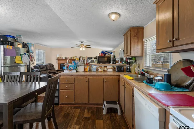 a kitchen that has a lot of cabinets a sink and appliances