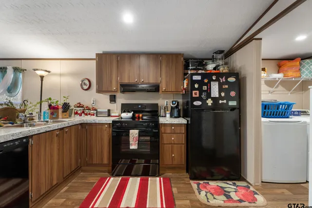 a kitchen with a sink a refrigerator and cabinets