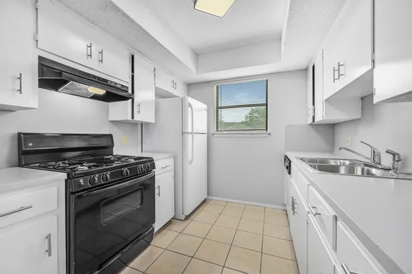 a kitchen with stainless steel appliances granite countertop a sink and white cabinets