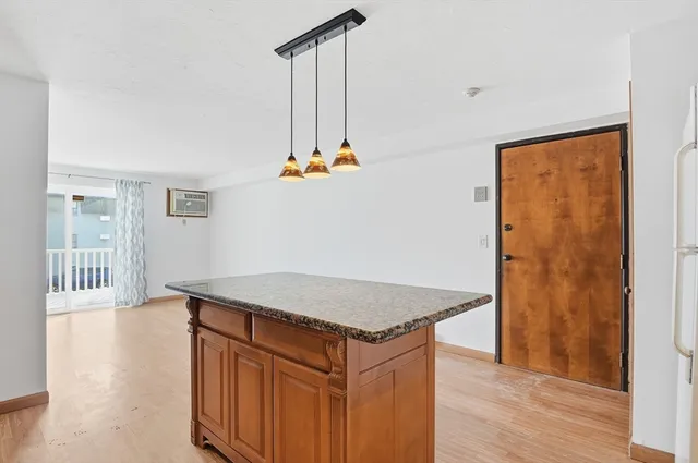 a kitchen with stainless steel appliances granite countertop a sink a refrigerator and a stove with wooden floor