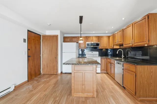 a kitchen with stainless steel appliances granite countertop a sink a stove and cabinets