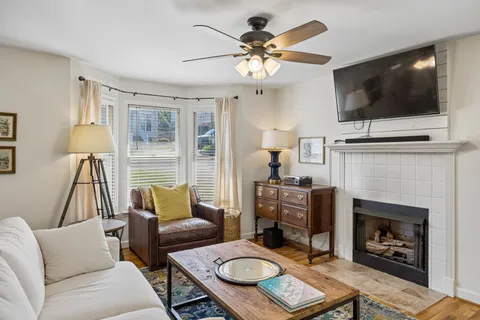 a living room with furniture a flat screen tv and a fireplace