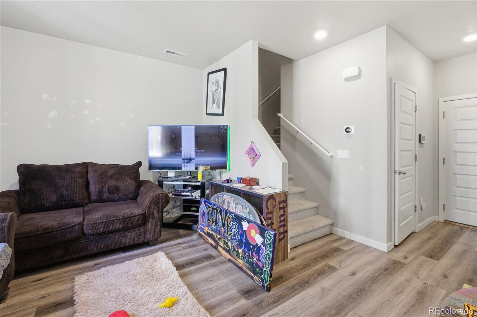 1353 Reynolds Street, Unit 11A Fort Lupton, CO 80621 - Photo 4 of 17 a living room with furniture and a wooden floor