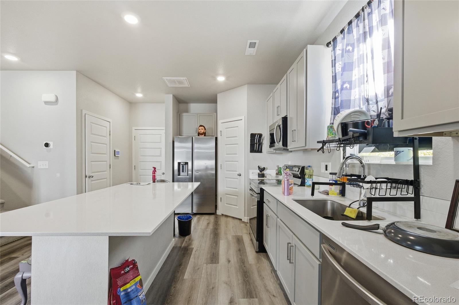 1353 Reynolds Street, Unit 11A Fort Lupton, CO 80621 - Photo 5 of 17 a kitchen with stainless steel appliances a sink a stove top oven a counter space and cabinets