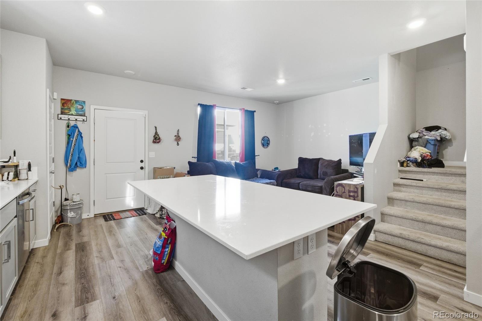 1353 Reynolds Street, Unit 11A Fort Lupton, CO 80621 - Photo 6 of 17 a large white kitchen with wooden floor