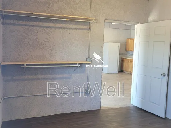a view of kitchen with stainless steel appliances granite countertop white cabinets and wooden floor
