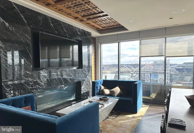 a living room with fireplace furniture and a floor to ceiling window