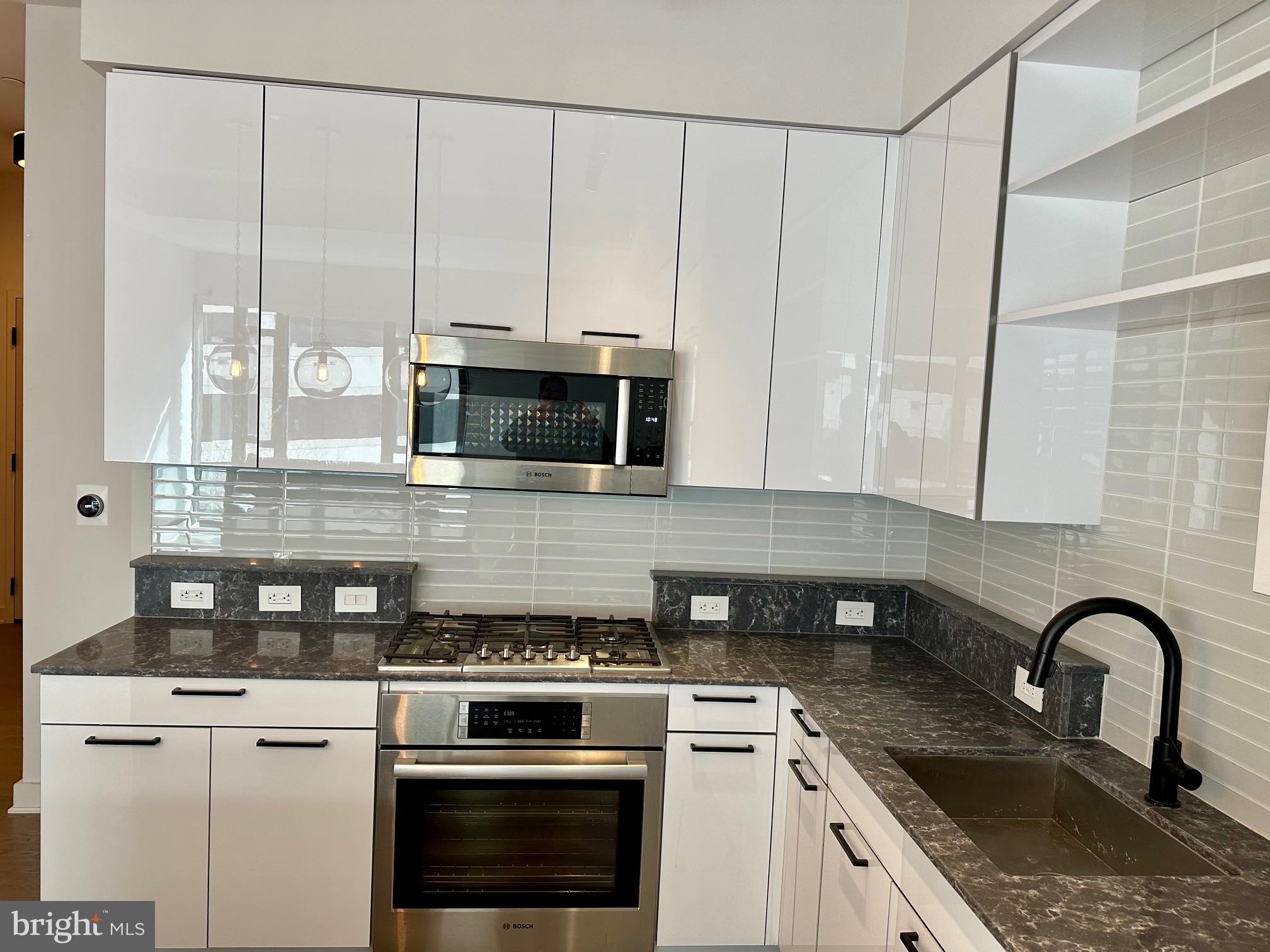 70 N Street Southeast, Unit N215 Washington, DC 20003 - Photo 4 of 16 a kitchen with stainless steel appliances granite countertop a stove a sink and white cabinets