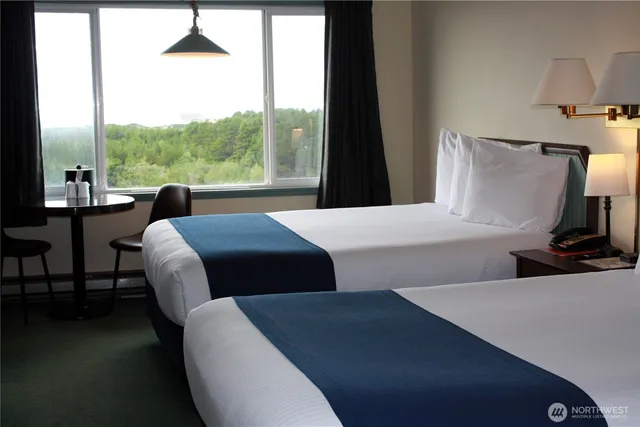 a bedroom with a bed and a flat tv screen on dresser