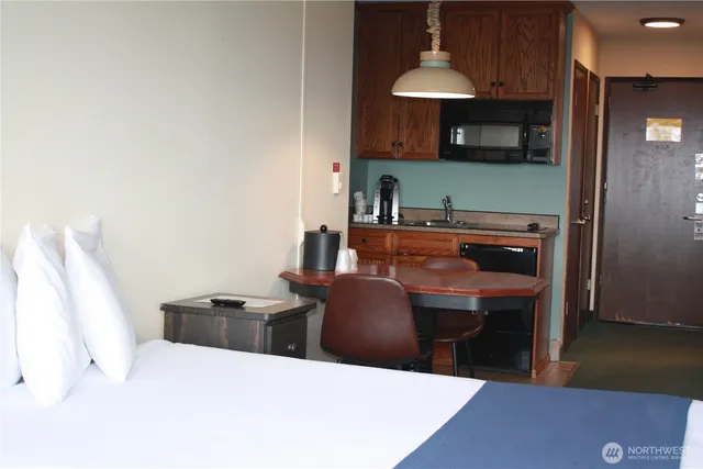 a kitchen with stainless steel appliances a stove a sink a microwave and dining table