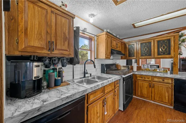 a kitchen with stainless steel appliances granite countertop a sink stove and cabinets