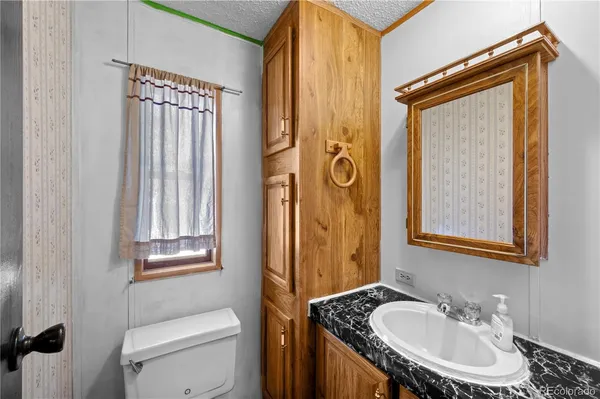 a bathroom with a sink a toilet and a mirror
