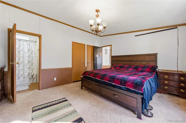 a spacious bedroom with a bed and a chandelier