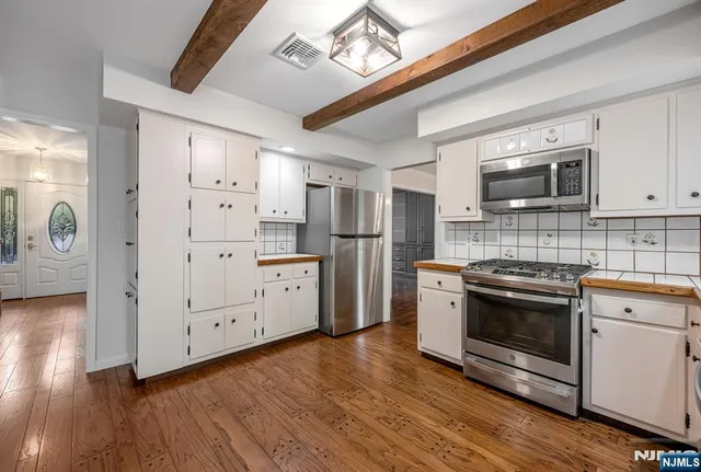 a kitchen with stainless steel appliances granite countertop a stove a refrigerator and a microwave oven