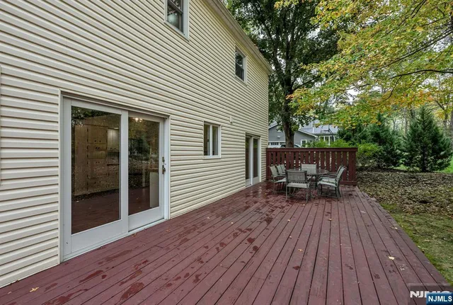 a view of house with deck outdoor seating and trees