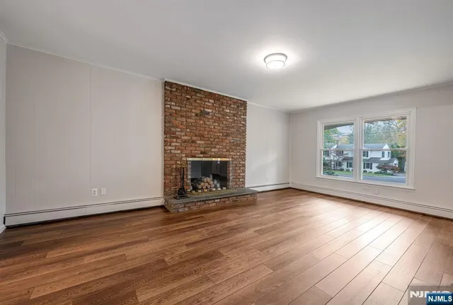 wooden floor fireplace and windows in an empty room