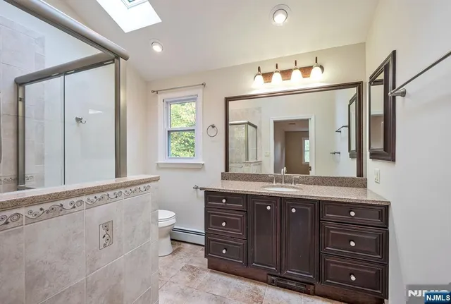 a bathroom with a granite countertop double vanity sink and a mirror