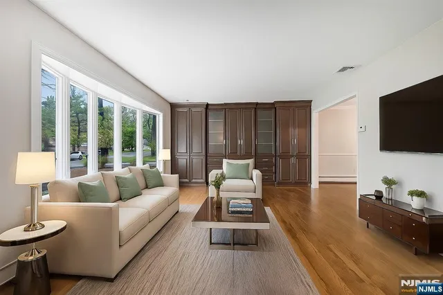 a living room with furniture a flat screen tv and a large window