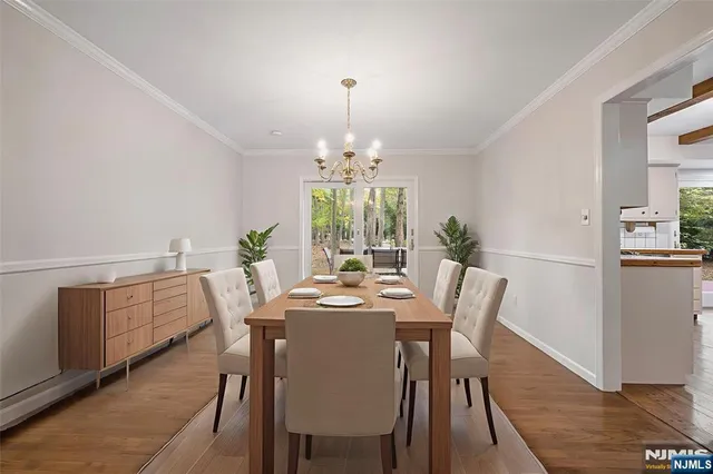 a dining room with furniture a chandelier and wooden floor
